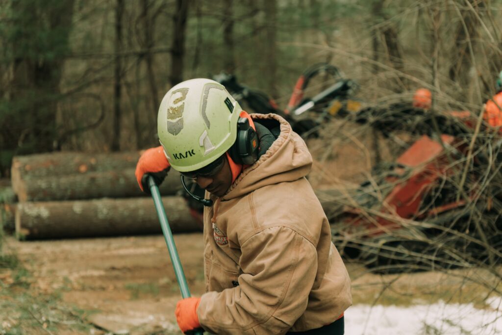 Walnut Tree Service worker with a tool in their hands clearing land.